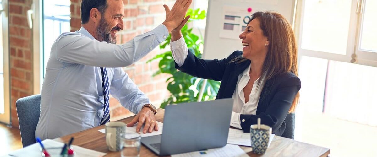 two person clapping hands after achieving sales excellence